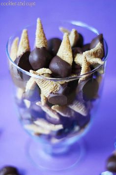 chocolate covered candy cones in a glass bowl on a purple tablecloth with other candies