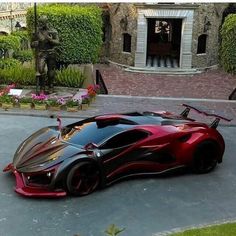 a red and black sports car parked in front of a house