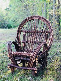 an old chair made out of logs in the grass