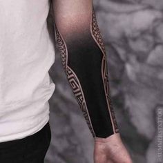 a man with a black and grey tattoo on his arm