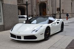 a white sports car parked in front of a building