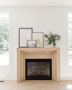 a living room with a fireplace and pictures on the mantle