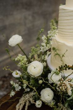 a wedding cake with white flowers and greenery