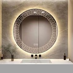 a bathroom with a round mirror and lights on the wall above it's sink