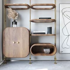 a shelf with books, vases and other items on it in a living room