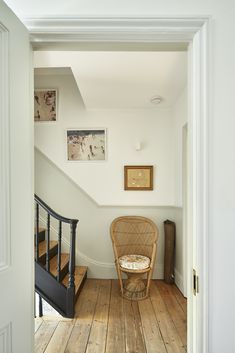 a chair sitting on top of a wooden floor next to a stair case