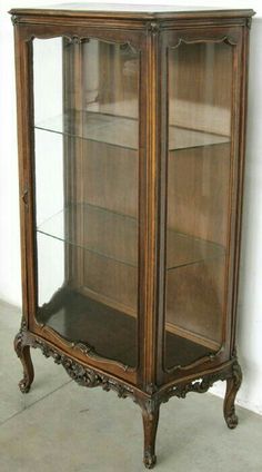 an antique china cabinet with glass doors and carved wood trimmings on the sides