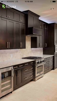 a kitchen with black cabinets and stainless steel appliances