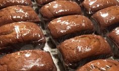 chocolate muffins wrapped in plastic sitting on top of a counter