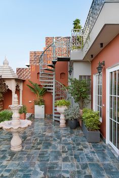 an outdoor courtyard with stairs and potted plants