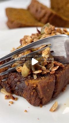 a piece of bread with nuts on it and a fork stuck into the top slice