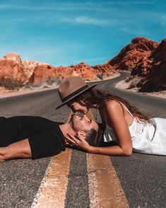 a man and woman laying on the road