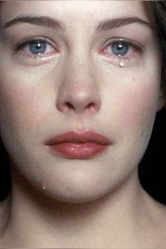 a close up of a woman's face with drops of water on her eyes