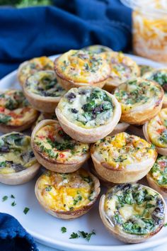 mini quiches filled with cheese and vegetables on a white plate