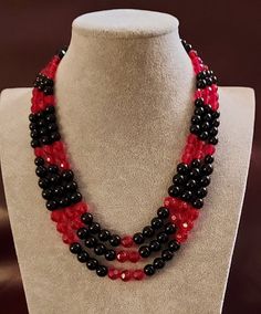 3-Strand Red and Black Necklace. It is made with Red Faceted Glass fishing beads and larger Red Faceted Glass beads. The Black beads include Black Plastic fishing beads, Black Faceted Onyx, and Black Round Onyx. The Closure is a 3-Strand Connector with Silver-plated Lobster Clasp. The length is 20-inches. Unique Red Necklace With Black Beads, Red Multi-strand Beaded Necklaces With Large Beads, Handmade Multi-strand Black Necklace, Artisan Red Multi-strand Necklace, Black Multi-strand Necklace With Faceted Beads, Red Necklace, Black Necklace, Faceted Glass, Multi Strand Necklace