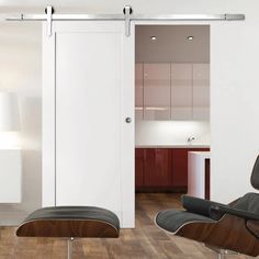 an eames chair and ottoman sit in front of a sliding door