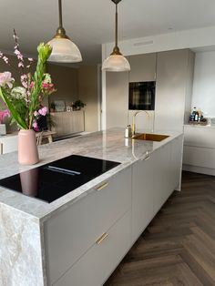 a modern kitchen with marble counter tops and gold accents