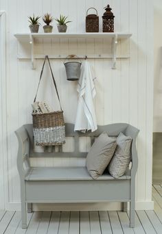 a bench with two baskets on it next to a shelf