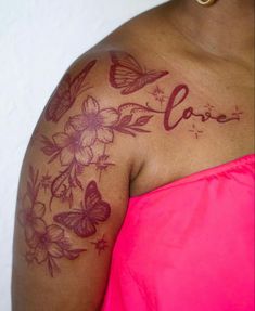 a woman's chest with flowers and butterflies on her left arm that says love