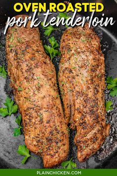 two cooked pork tenders on a black plate with parsley sprinkled over them