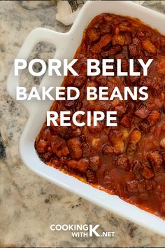 pork belly baked beans recipe in a white dish on a marble counter top with text overlay