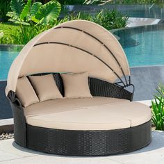 an outdoor daybed with cushions and pillows next to a pool