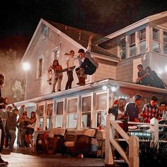 a group of people standing on top of a house