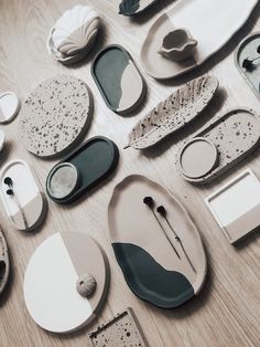 many different types of plates and spoons on a wooden table with white and black designs