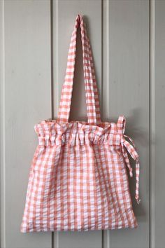 an orange and white gingham bag hanging on a wall