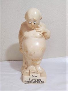 a ceramic statue of a baby holding his hands to its chest with the words i love you just the way you are written on it