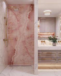 a bathroom with pink marble and gold fixtures