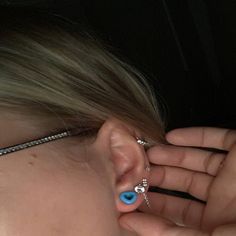 a woman with blue eyes and piercings on her ear