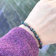 Check out this showstopper! The beautiful metallic jewel tone colors of the hematite beads are striking against the black and silver stainless steel. #elasticbracelet #stretchbracelet #mysticjewelry #handmadejewelry #hematitebracelet #beadedbraceletsforwomen #uniquestyle #giftforher #loralyndesigns Rainbow Hematite, Metallic Rainbow, Edgy Jewelry, Rocker Chic