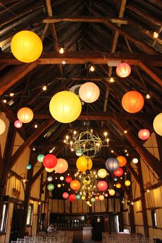 a large room filled with lots of colorful paper lanterns hanging from the ceiling and chandeliers