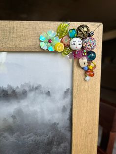 an old photo frame with some colorful beads on it