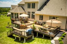 an aerial view of a large house with decking and umbrellas in the yard