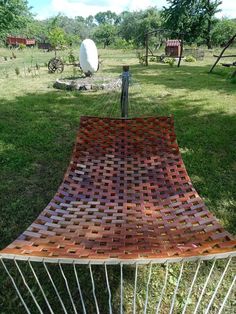 a wooden bench sitting on top of a lush green field next to a metal fence