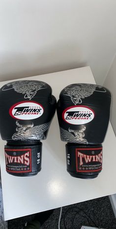 two black boxing gloves sitting on top of a table