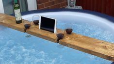 a tablet computer sitting on top of a wooden table in a hot tub