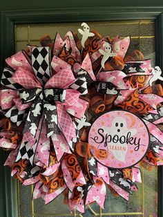 a pink and black halloween wreath on the front door with spooky season stickers