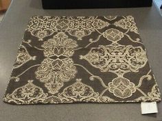 a brown and white area rug sitting on top of a counter next to a black box