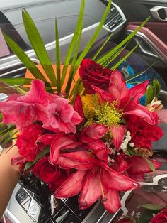 a bouquet of red flowers sitting on top of a car dashboard