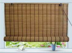 the bamboo blinds are hanging in front of a window with flowers and daisies on it