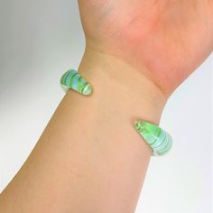 This bracelet is as tough as it is unique. If you break it we will ship you a new one for free. The intriguing contours create a sensual form. Our Borosilicate glass artisan cuff bracelets are handmade by glass craftsmen with the centuries-old process known as lampwork. The borosilicate glass is molded and formed into the cuff shape with precision and attention to detail. The cuff is then annealed in a kiln to ensure durability and strength, making it the perfect material for unique wearable art Unique Adjustable Green Bangle, Unique Green Adjustable Bangle, Adjustable Resin Bangle Jewelry, Adjustable Resin Bangle, Green Plastic Bracelet Jewelry, Green Plastic Bracelet, Unique Adjustable Resin Bracelets, Dog Carrier Sling, Dog Sling