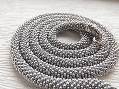 A handmade silver snake necklace from high-quality seed beads, cotton yarn with a snake head and tail clasps (jewelry hypoallergenic aluminum) is very flexible and comfortable to wear. * MEASUREMENTS: Necklace Length on photo: 40 inches (100 cm). Custom length available! Custom colors available! * This snake necklace could be lovely accessorize for your look every day, or special evening. This beaded necklace also is a perfect accessory, which can be worn formally or casually to add style to you Silver Necklace With 108 Round Beads, Handmade Silver Snake Necklace, Spiral Beaded Silver Jewelry, Silver Spiral Beaded Jewelry, Silver Snake Necklace, Snake Choker Necklace, Serpent Necklace, Snake Necklace Silver, Wiccan Necklace