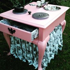 a pink table with two stoves on it and a sink in the middle,