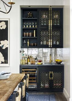 a kitchen with black cabinets and gold accents