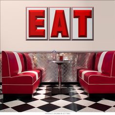 two red chairs sitting next to each other in front of a wall mounted sign that says eat here barbeque cocktails good food - cold - cold beer