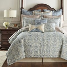 a bed in a bedroom with blue and white comforter sets on top of it