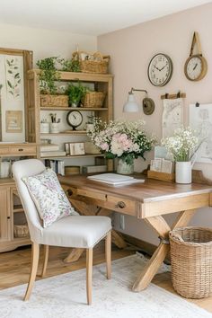 a wooden desk topped with a white chair next to a shelf filled with flowers and clocks